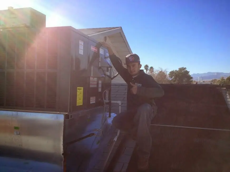 HVAC technician performing Boiler Repair on a rooftop unit in Conley